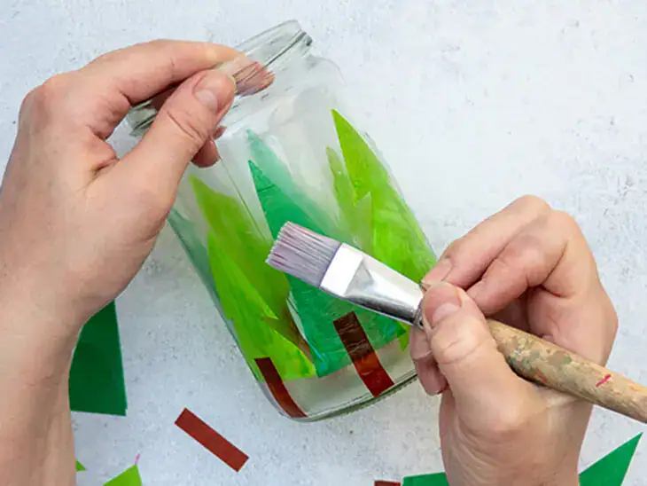 Jemand wickelt weiße Filzwolle von KNORR prandell um den Rand eines Windlichts. Foto: Johanna Rundel