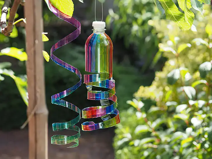 Zwei DIY-Sonnenfänger aus PET-Flaschen hängen im Garten am Baum. Foto: Johanna Rundel