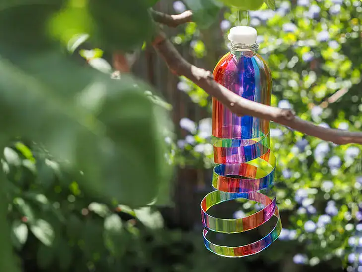Ein DIY-Sonnenfänger aus PET-Flaschen hängt im Garten am Baum. Foto: Johanna Rundel