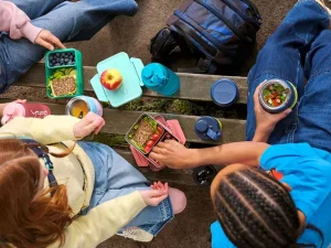 Eine Gruppe Teenager macht Pause mit Brotdosen und Trinkflaschen von satch.