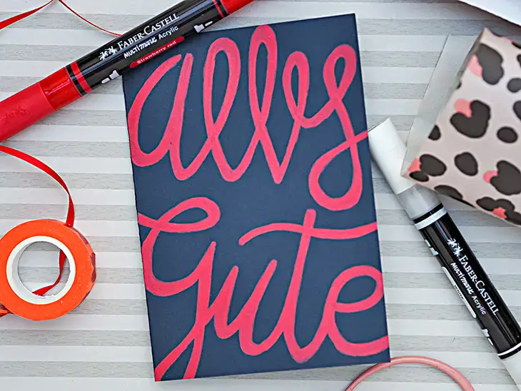Dunkle Grußkarte auf die mit Acrylmarker von Faber-Castell „Alles Gute“ gelettert wurde. Foto: Johanna Rundel Dunkle Grußkarte auf die mit Acrylmarker von Faber-Castell „Alles Gute“ gelettert wurde. Foto: Johanna Rundel