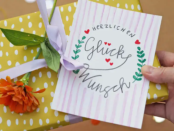 Jemand überreicht ein Geschenk mit einer handgeletterten Geburtstagskarte. Foto: Johanna Rundel Jemand überreicht ein Geschenk mit einer handgeletterten Geburtstagskarte. Foto: Johanna Rundel